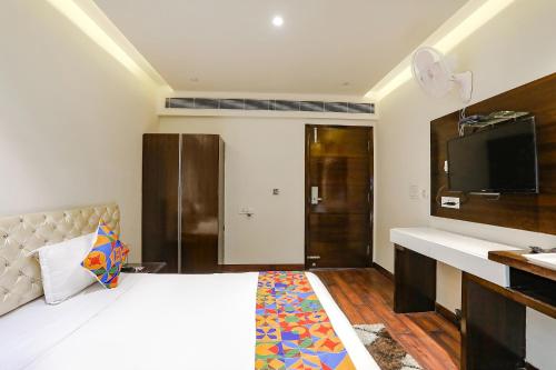 a hotel room with a bed and a tv at FabHotel Grand Stay in New Delhi