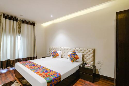 a bedroom with a large bed and a window at FabHotel Grand Stay in New Delhi