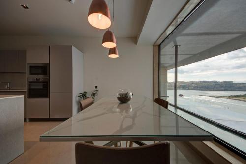 a glass table in a kitchen with a view of the ocean at Land's End, Boutique Hotel in Sliema