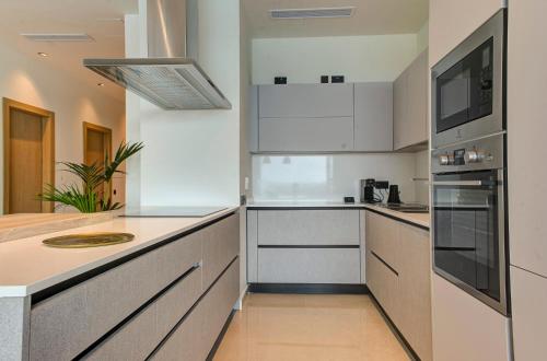 a kitchen with white cabinets and a counter top at Land's End, Boutique Hotel in Sliema