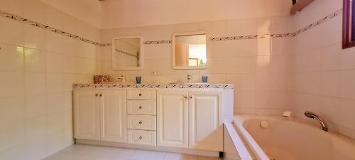 ein Badezimmer mit einer Badewanne, einem Waschbecken und einem Spiegel in der Unterkunft Villa Casa Ismaia avec piscine au calme in Montauroux