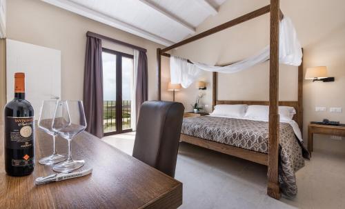 1 dormitorio con 1 cama y 1 mesa con copas de vino en Firriato Hospitality - Baglio Sorìa, en Trapani