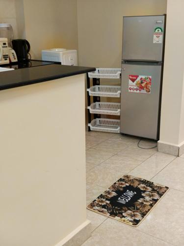 a kitchen with a refrigerator and a welcome mat on the floor at Luxurious 2bedroom furnished apartment in Nairobi
