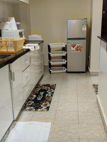 a kitchen with a refrigerator and a tile floor at Luxurious 2bedroom furnished apartment in Nairobi