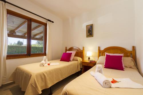 two beds in a room with a window at Villa Jaume in Pollença