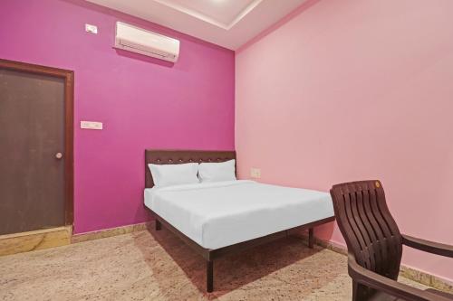 1 dormitorio con cama y pared púrpura en Super Capital O Hotel Sai Balaji Near Golconda Fort, en Hyderabad