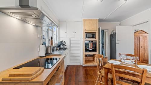 a kitchen with a table and chairs in a room at The Remodelling Room - Mount Maunganui Cottage in Matapihi