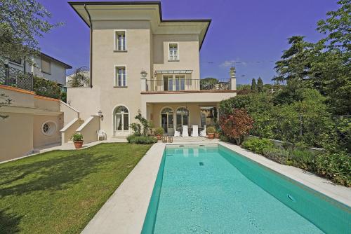 a large house with a swimming pool in front of it at Villa San Carlo - Gardagate in Roe