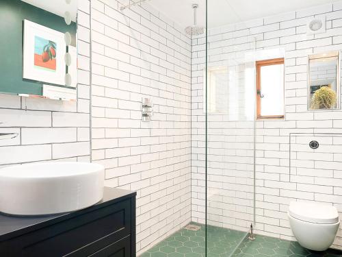 uma casa de banho branca com um lavatório e um WC em Lantern Lodge em Bramley