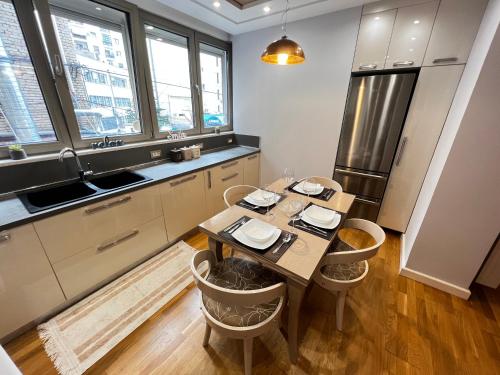 a kitchen with a table with chairs and a refrigerator at Tirana center in Tirana