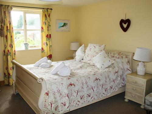 a bedroom with a bed with towels on it at Carrot Cottage - Uk32609 in Manton