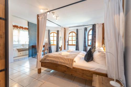 a bedroom with a canopy bed and a bathroom at Ackerweg Ferienwohnungen in Ueckeritz