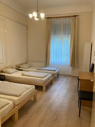 a room with three beds in it with a window at Gogol24 in Szeged