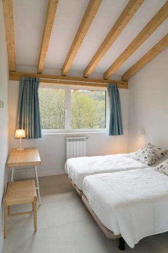 a bedroom with a large bed and a window at Villa El Rodal in Pontones