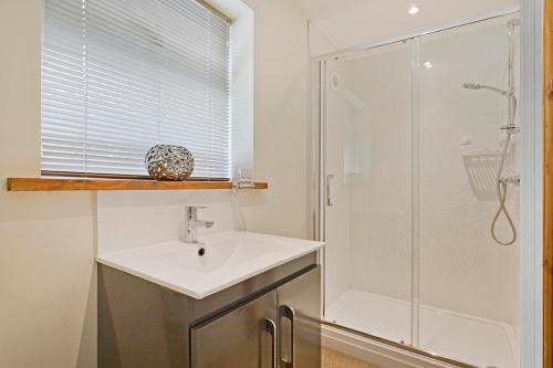 a bathroom with a sink and a shower at Plum Cottage in Knaresborough