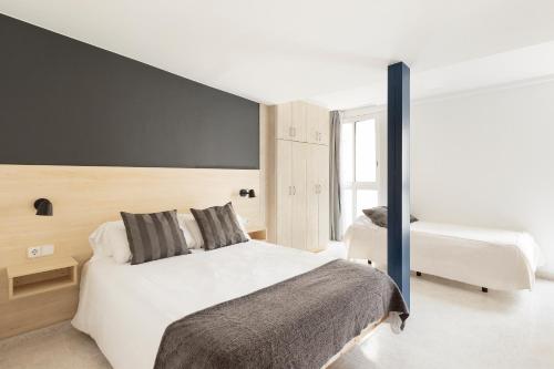 a bedroom with two beds and a black wall at Andreas Apartments in Tarragona