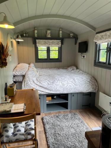 a bedroom with a bed in a tiny house at Greatwood Shepherds Hut in Battle