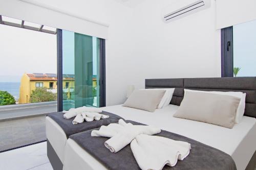 ein Schlafzimmer mit einem großen weißen Bett mit Handtüchern darauf in der Unterkunft Villa Mey in Protaras