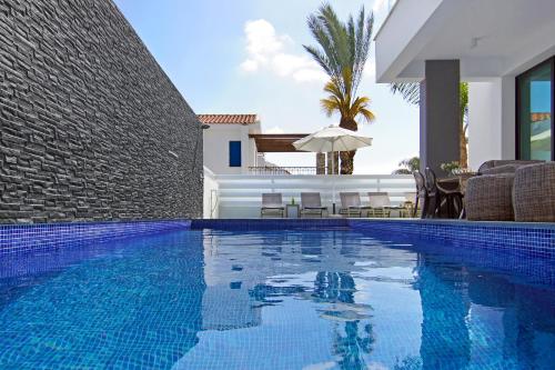una piscina con sedie e una casa di Villa Mey a Protaras