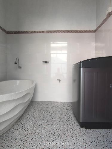 a white bathroom with a tub and a sink at Konex Homestay in Canggu