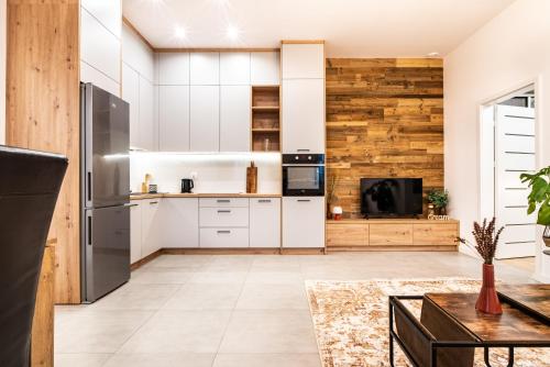 - une cuisine avec des placards blancs et un mur en bois dans l'établissement ApartamentySnu, Jagielloński Premium II z parkingiem, Centrum, à Radom