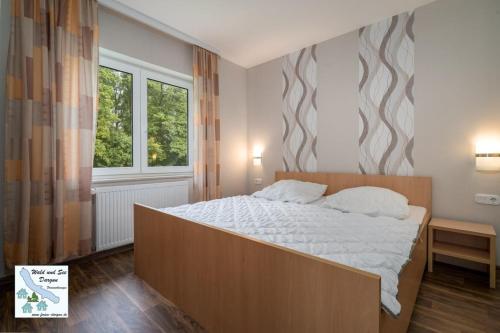 a bedroom with a large bed and a window at Wald und See Dargun 16A in Dargun