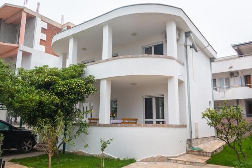 a white house with a round driveway at Holiday Home Adria in Dobra Voda