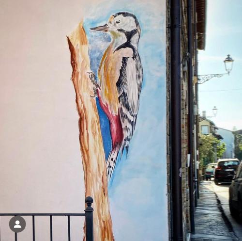 a painting of a bird on a tree branch at Il Nido del Picchio in Ascoli Piceno