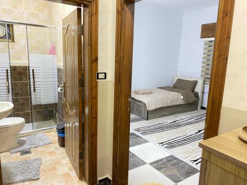 a bathroom with a shower and a bedroom with a bed at Jasmine's House in Jerash