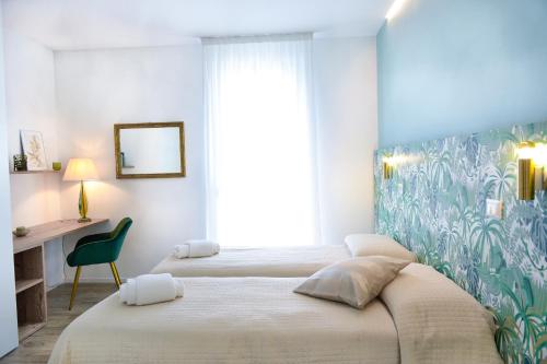 1 dormitorio con 2 camas y escritorio con espejo en Residenza Emilia, en Padua