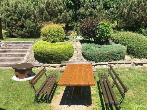 a wooden table and two benches in a park at Znamirówka in Znamirowice