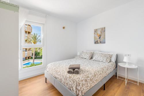 - une chambre blanche avec un lit et une fenêtre dans l'établissement Lopimar Playa, à Canet d'En Berenguer