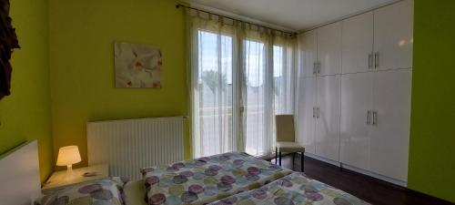 a green bedroom with a bed and a window at Viktória Beach Apartman Gold 2. Siófok in Siófok