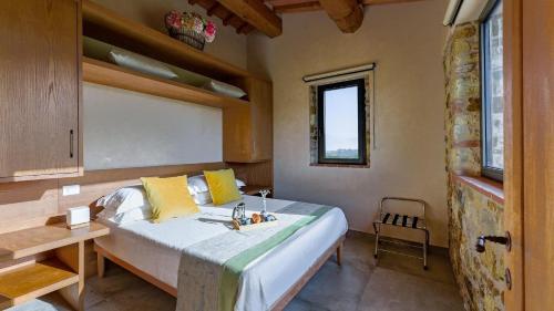 - une chambre avec un lit, une table et une fenêtre dans l'établissement La Pagliera di Badia a Passignano, à Badia A Passignano
