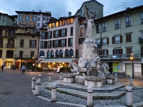 eine Statue in der Mitte eines Platzes mit Gebäuden in der Unterkunft Casa Marina in Lovere