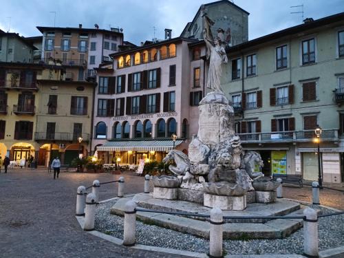 a statue in the middle of a square with buildings at Casa Marina in Lovere