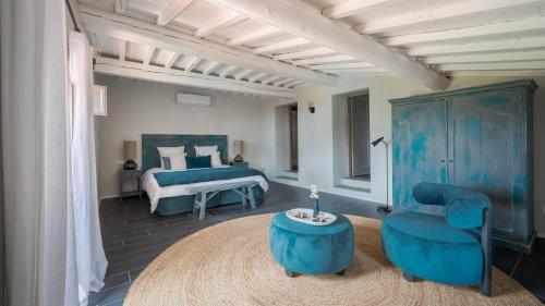 um quarto com uma cama azul e uma cadeira azul em Casale San Vincenti em Gaiole in Chianti