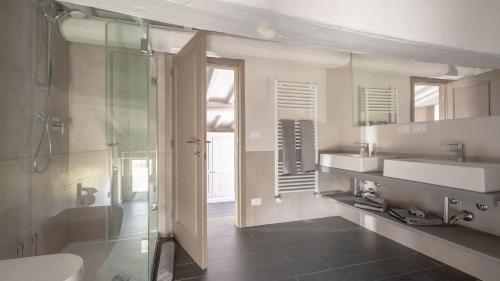 uma casa de banho com uma cabina de duche em vidro e um lavatório. em Casale San Vincenti em Gaiole in Chianti