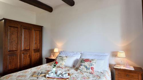 Roccalbegna的住宿－Ginepro，一间卧室配有一张带两盏灯和两个枕头的床。