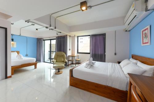 una habitación de hotel con 2 camas y una silla en Na BaanYa Chiang Mai en Chiang Mai