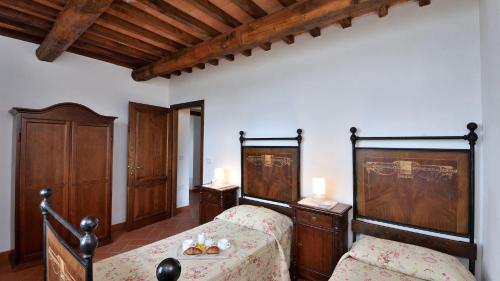 1 Schlafzimmer mit 2 Betten und Holzmöbeln in der Unterkunft Melograno in Roccalbegna