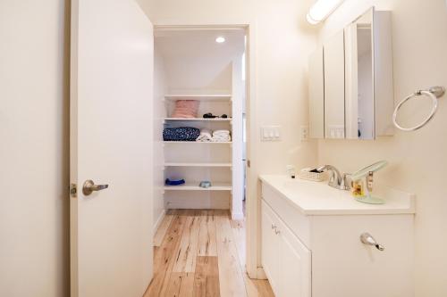 a white bathroom with a sink and a mirror at Hollywood Sign View in Modern 1 Bedroom Loft in Los Angeles