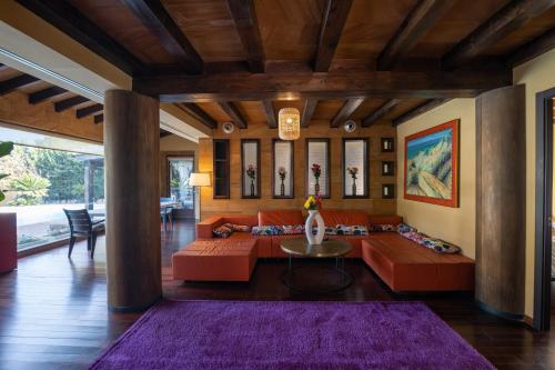 sala de estar con sofás naranjas y alfombra morada en Villa Huerta 2, jacuzzi, sauna, en Paterna
