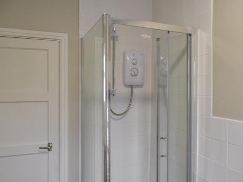 a shower with a glass door in a bathroom at Russell Retreat in Skipton