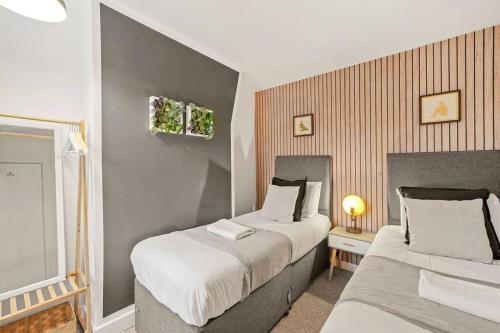 een slaapkamer met 2 bedden en een raam bij Aesthetic Cambridge Cottage sleeps 5! in Cambridge
