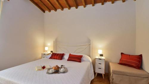 a bedroom with a large white bed with red pillows at Podere La Casa in Cavriglia