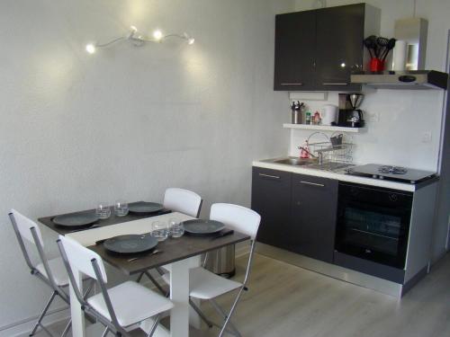 une cuisine avec une table et des chaises dans une cuisine dans l'établissement studio tout équipé place de parking centre port, au Cap d'Agde