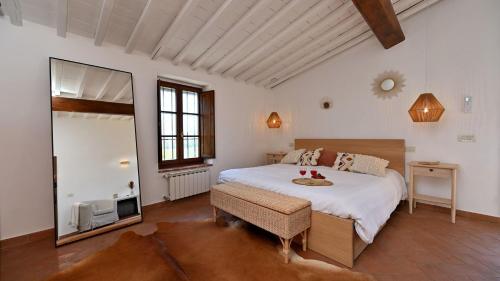 a bedroom with a large bed and a mirror at La Porcilaia in Castelnuovo Berardenga