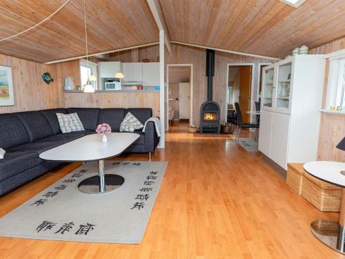 a living room with a couch and a table at 6 person holiday home in Hj rring in Lønstrup