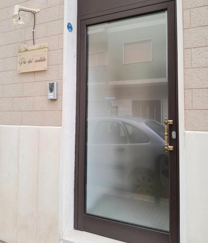 a door with a car reflection in the window at Dimora Pié del Castello in Conversano
